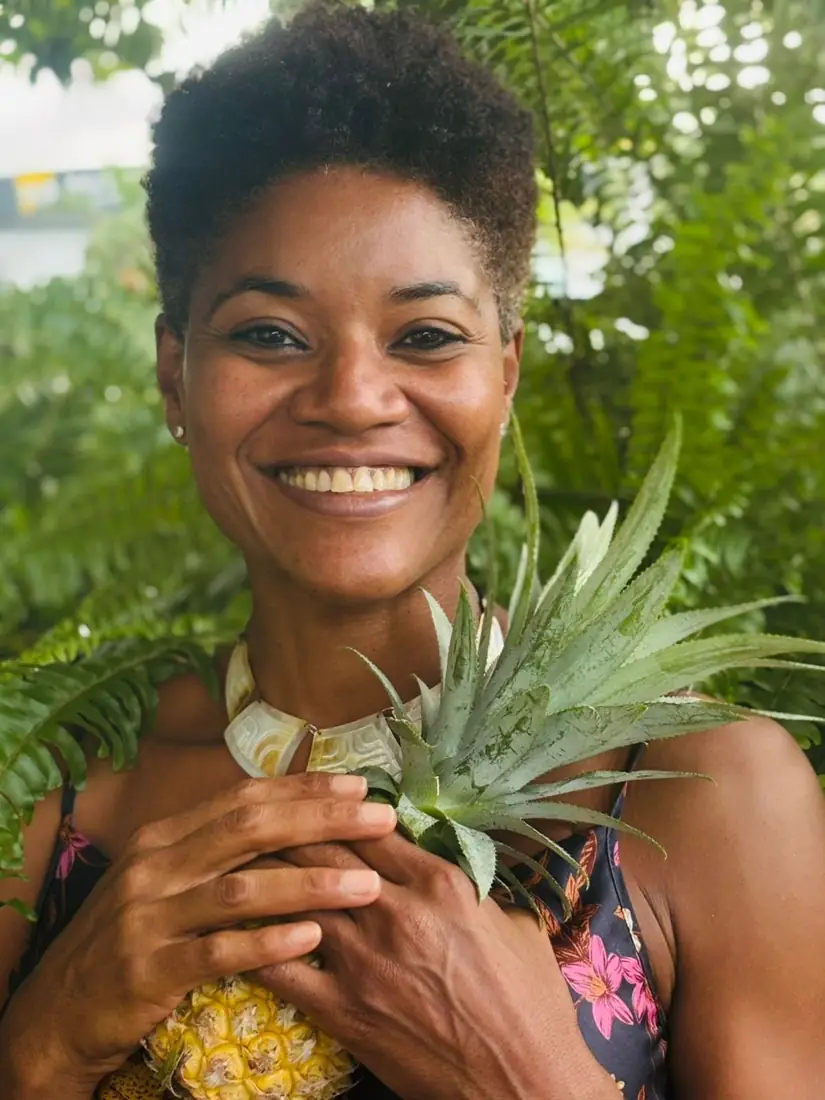 Manuella Dando, naturopathe en Guadeloupe, souriante avec un ananas